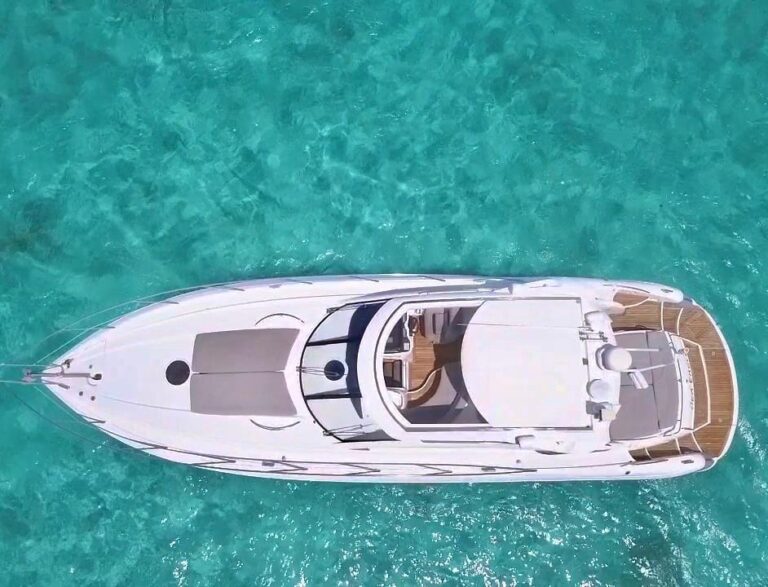 Vista de estribor del yate charter de lujo Sunseeker Sea Eagle 50 ft fondeado en aguas turquesas cristalinas del Caribe cerca de Cancún