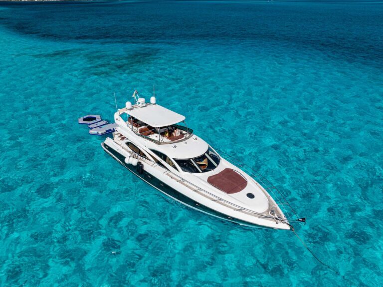 Aerial top-down view of 64 ft Sunseeker Fibrax King yacht anchored over crystal-clear turquoise Caribbean sea near Isla Mujeres Cancun