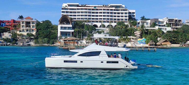 Vista aérea de proa del yate charter de lujo Leopard power catamaran 51 ft fondeado en aguas turquesas brillantes del Caribe cerca de Cancún, diseño de doble cubierta