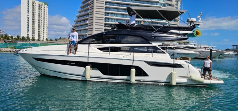 Vista aérea del yate charter de lujo Fairline Squadron 53 ft navegando por aguas turquesas del Caribe cerca de la costa de Cancún al atardecer en hora dorada