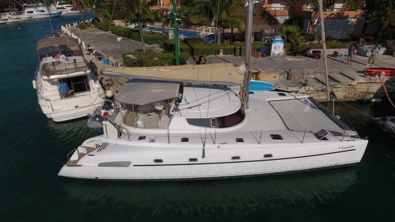 Aerial dock view of 46 ft sailing catamaran Lazy Linda at Puerto Aventuras marina Riviera Maya � white hull, cockpit and bow platforms, luxury charter for 25 guests