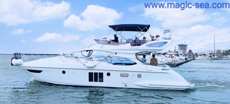Renta del yate Azimut 50 ft en Cancún con un invitado posando en la proa, hotel RIU y marina al fondo