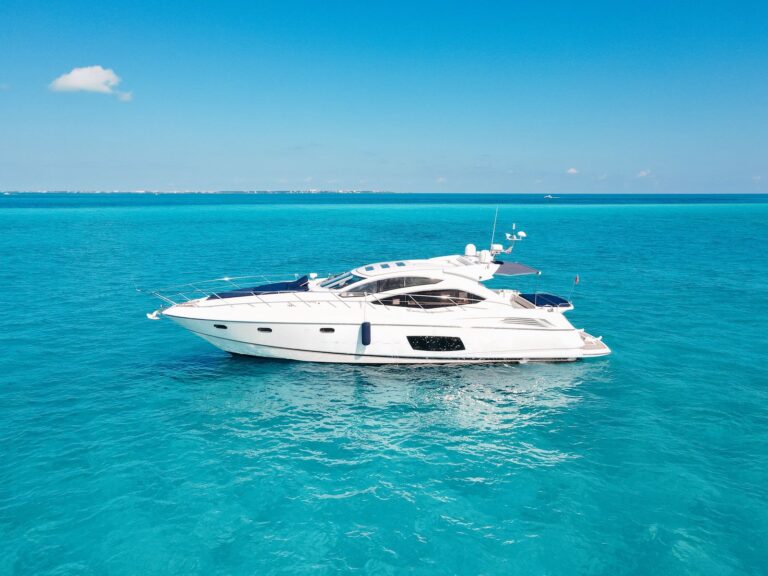 Aerial side view of 64 ft Sunseeker Predator Pure Life luxury yacht anchored in brilliant turquoise Caribbean sea near Isla Mujeres Cancun