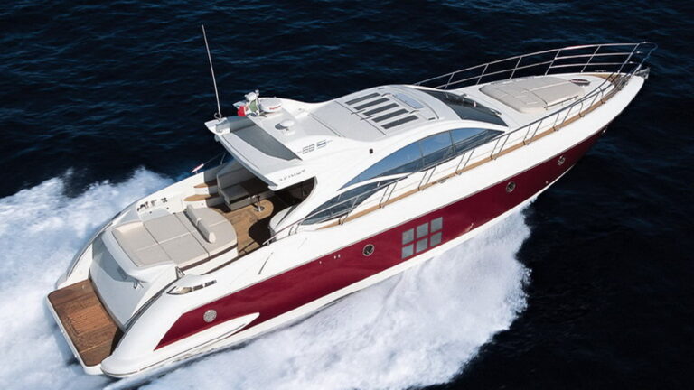 Aerial view of 68 ft Azimut Sport luxury yacht charter with bold red and white hull racing at full speed across dark blue open ocean