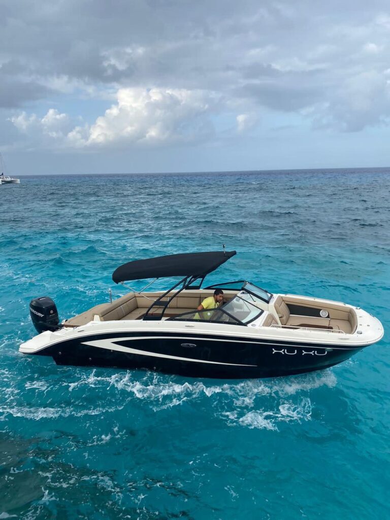 26 ft Sea Ray Sundeck sport boat Xu Xu with sleek black hull and tan interior moving through turquoise Caribbean water at Cozumel island charter rental.