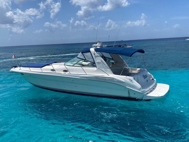 Side profile of white 40 ft Sea Ray Ohana express cruiser anchored in brilliant turquoise Caribbean water at Cozumel island yacht charter rental.