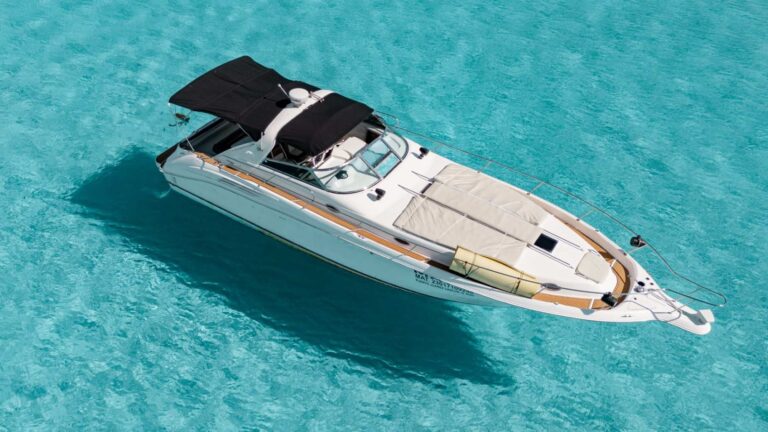 Aerial overhead view of 45 ft Sea Ray Mavie luxury yacht anchored in brilliant turquoise Caribbean near Cancun, teak side accents and bow sun pad visible.