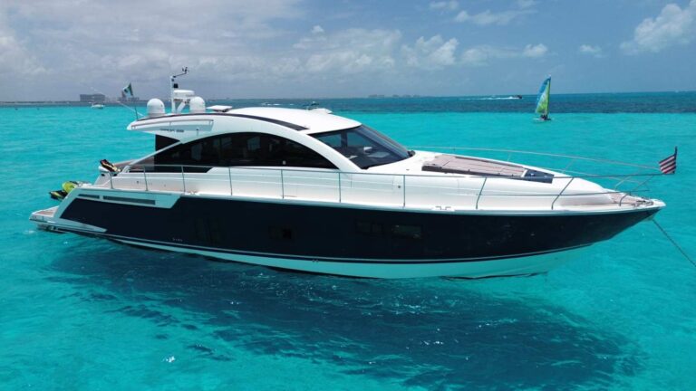 58 ft Fairline Targa 58 Gran Turismo luxury charter yacht with navy hull anchored in turquoise Caribbean water near Cancun Isla Mujeres.