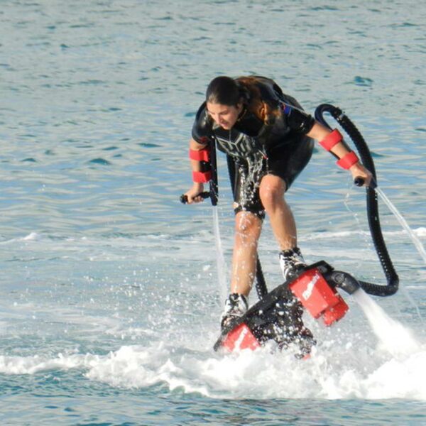 Woman flyboards above the water on a jet powered hydro flight board during an action packed Cancun water sports session.