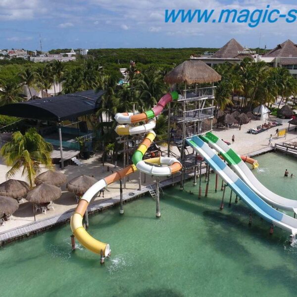 Aerial view of the colorful waterpark slides and palapas at a Caribbean beach club near Cancun, MagicSea excursion stop.